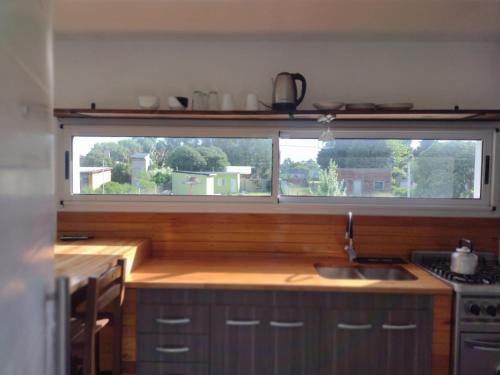 a kitchen with a large window above a sink at Casa container in Mar del Plata
