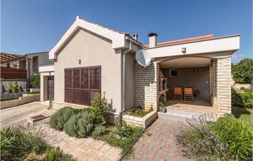 a white house with a garage and a patio at Cozy Home In Maslenica With Wifi in Maslenica