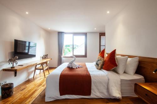 a bedroom with a bed and a desk and a television at Seminyak Villa Paya paya Luxury near beach-Potato Head in Seminyak