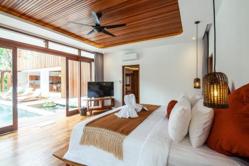 a bedroom with a large bed with a ceiling fan at Seminyak Villa Paya paya Luxury near beach-Potato Head in Seminyak