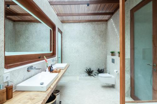 a bathroom with a sink and a toilet and a mirror at Seminyak Villa Paya paya Luxury near beach-Potato Head in Seminyak