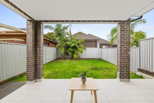 an empty backyard with a fence and a table at Detached Double Room in Revesby - Tranquil Place - Shared Bathroom in Revesby