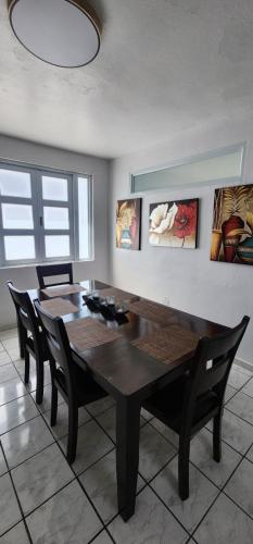 a dining room with a wooden table and chairs at Kali-Yaiti Casa Vacacional in Vega Baja