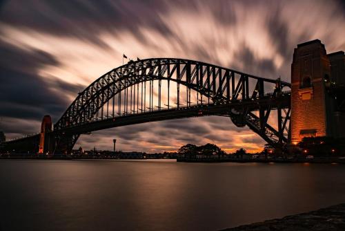 a bridge over a body of water with a cloudy sky at Modern Queen Room - Private Spot at Revesby - Shared Bathroom in Revesby