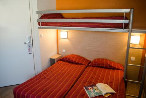 Un dormitorio con una litera con un libro. en HECO Calais Centre-Gare, en Calais