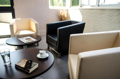 a living room with two chairs and a table and a chair and a coffee table at HECO Calais Centre-Gare in Calais