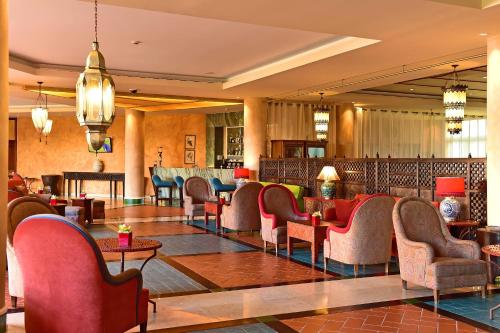 un hall avec des chaises et des tables ainsi qu'un bar dans l'établissement Pestana Sintra Golf Resort & SPA Hotel, à Sintra