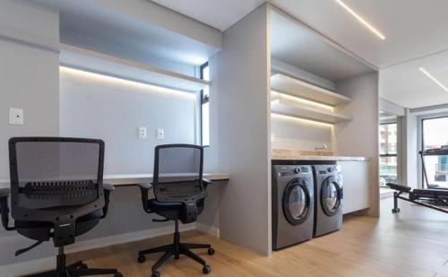 a laundry room with two desks and two chairs at Varanda do Mar - Flat Intermares in Cabedelo