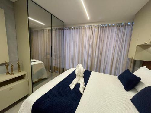 a white teddy bear sitting on a bed in a bedroom at Varanda do Mar - Flat Intermares in Cabedelo