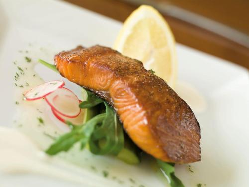 a plate of food with a piece of fish and vegetables at Macdonald Berystede Hotel & Spa in Ascot