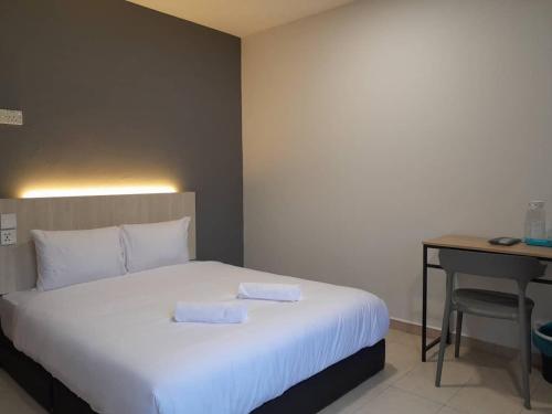 a bedroom with a bed with two towels on it at The Great Hotel in Ipoh