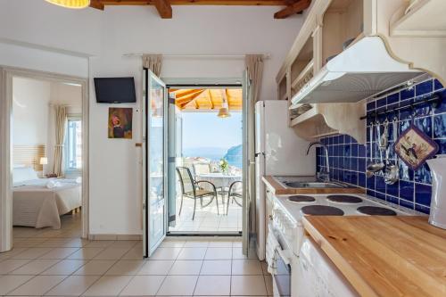a kitchen with a view of the ocean from a balcony at Thea Home Hotel by Booking Kottas in Skopelos Town