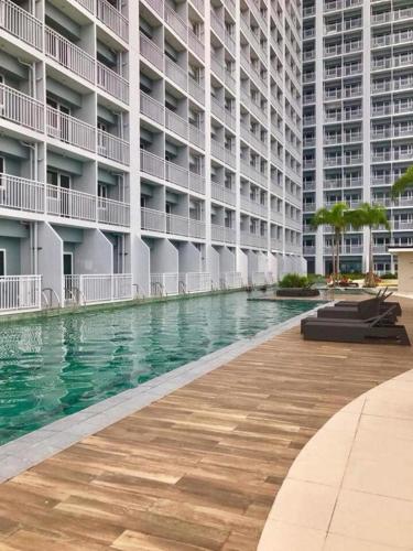 a swimming pool in front of a large building at Rhoydez Condotel Breeze Residence in Manila