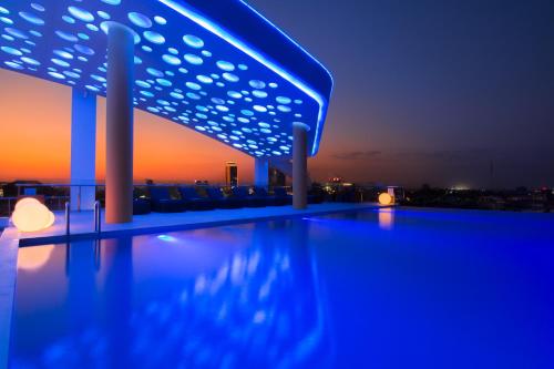 a pool on the roof of a building at night at SUN & MOON, Urban Hotel in Phnom Penh