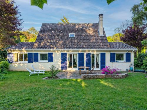 une maison bleue et blanche avec une cour dans l'établissement L'Haricotier, à Lésigny