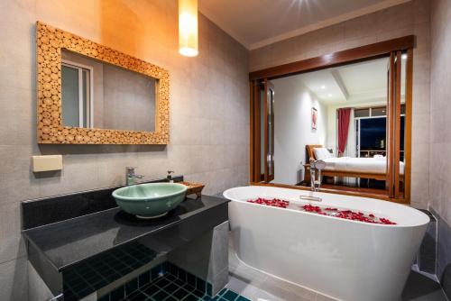 a bathroom with a large tub and a sink at Prima Villas Karon Phuket in Karon Beach