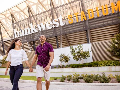 a man and a woman walking in front of the stadium at Novotel Sydney Parramatta in Sydney