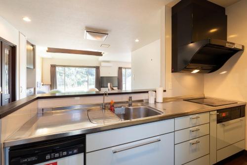 a large kitchen with a sink and a stove at S-villa Minamiboso rosemar in Awa