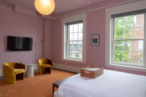 フランクフォートにあるThe Ashbrook Hotelのベッドルーム1室(ベッド1台、椅子2脚、テレビ付)