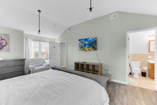 a white bedroom with a bed and a desk at NYC & Downtown Newark Commuter Dream Stay in Newark