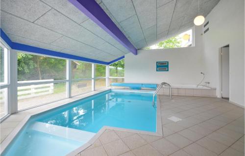 a swimming pool in a house with a large window at Awesome Home In Ebeltoft With Sauna in Ebeltoft