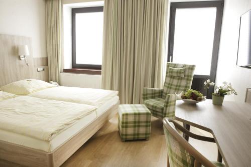 a hotel room with a bed and a desk and a table at Hotel Kirchspiels Gasthaus in Nortorf