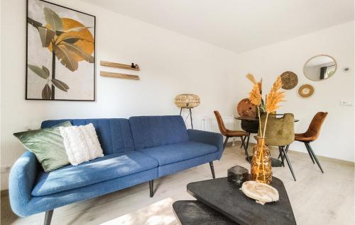 a blue couch in a living room with a table at 2 Bedroom Cozy Home In Heinkenszand in Heinkensand