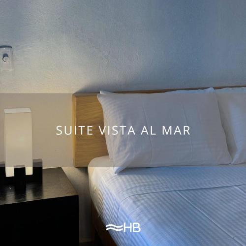 a bed with a white pillow with the words suite missa all marauder at Hotel Barra de Navidad in Barra de Navidad