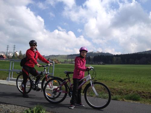 a man and a girl riding bikes on a road at Apartmán u Kamila in Dolní Morava