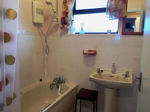 a bathroom with a sink and a bath tub at Cottage 188 - Ballyconneely in Ballyconneely