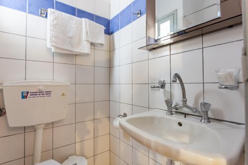 a bathroom with a sink and a toilet at Thea Home Hotel by Booking Kottas in Skopelos Town