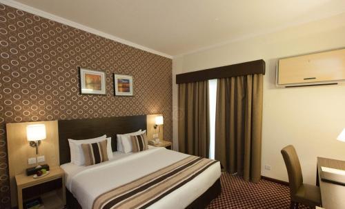 Postel nebo postele na pokoji v ubytování Fortune Karama Hotel