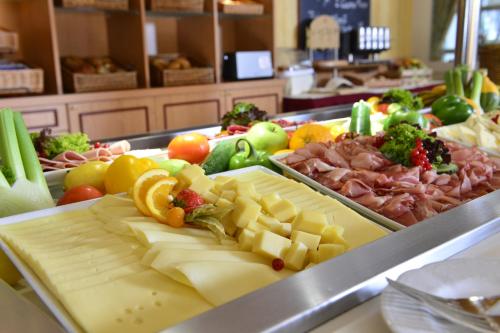 a buffet line with cheese and meats and vegetables at PLAZA INN Leonberg in Leonberg