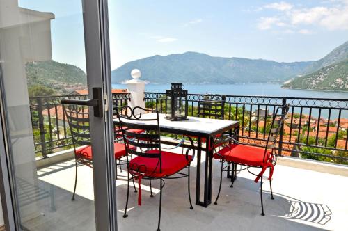 a table and chairs on a balcony with a view of the water at Apartments Castello Risano in Risan
