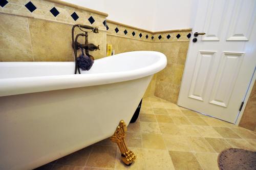a white bath tub in a bathroom next to a door at Apartments Castello Risano in Risan