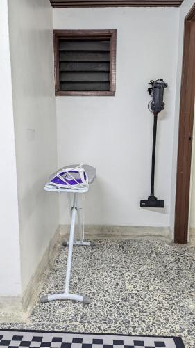 a table in front of a white wall with a window at Homestay Kemaman - Hitam Putih Homestay in Cukai