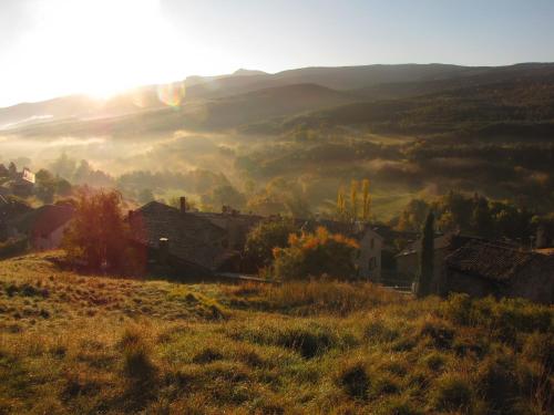 a small village in a field with the sun in the background at Gîte du Cladan in LʼÉpine