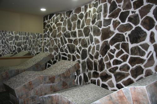 a stone wall with two stone benches in a room at Borjomi Palace Health & Spa Center in Borjomi
