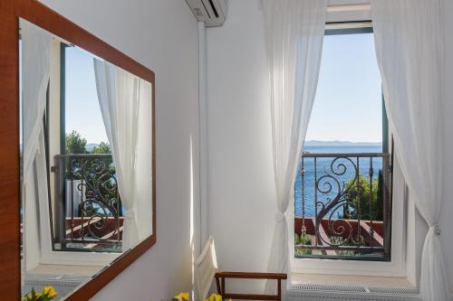 a room with a balcony with a view of the ocean at Villa Osibova in Milna