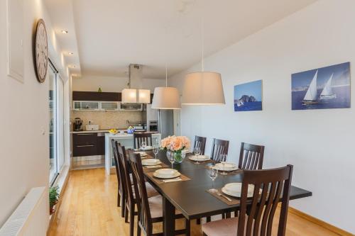 a kitchen and dining room with a table and chairs at Villa Osibova in Milna