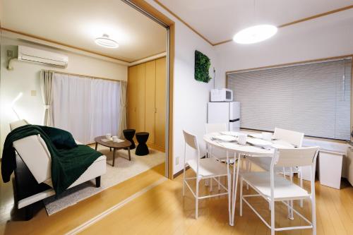 a dining room with a table and chairs in a room at アンファング森ノ宮 in Osaka