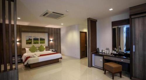 a bedroom with a bed and a desk in a room at The One Hotel in Bung Kan