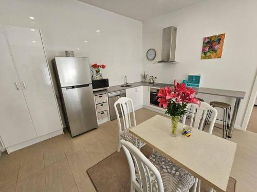 a kitchen with a table with a vase of flowers on it at Blossom Cottage - Cosy Retreat in Penna