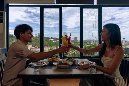 een man en vrouw aan een tafel met een drankje bij 360 Resort in Sihanoukville