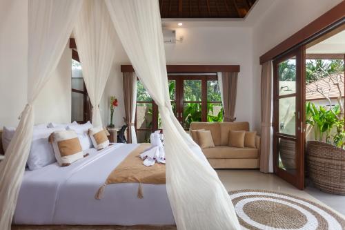 a bedroom with a bed with mosquito net at New! The Green Kulu a Romantic 1BDR Private Villa in Tampaksiring