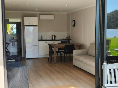 a kitchen and living room with a table and a couch at Braxmere Lodge in Turangi