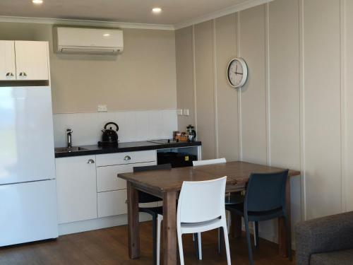 a kitchen with a table and chairs and a refrigerator at Braxmere Lodge in Turangi