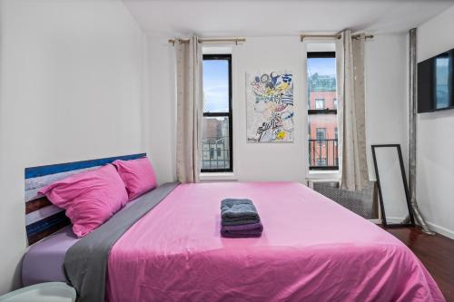 a large pink bed in a room with windows at Pinky Pinky 2 Bedroom in New York