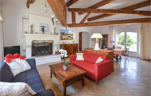 - un salon avec un canapé rouge et une cheminée dans l'établissement Gorgeous Home In Rochefort-Du-Gard, à Rochefort-du-Gard