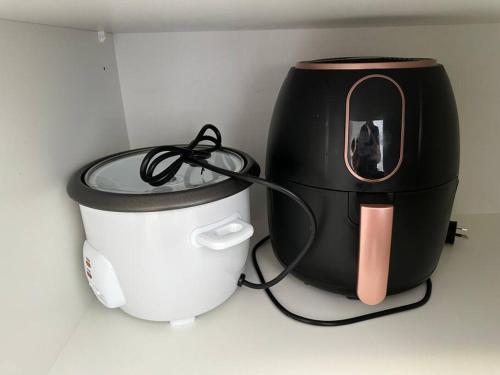 a dog in a mirror next to a rice cooker at Quiet, private studio 1 double bed and extra matress in Mount Pritchard